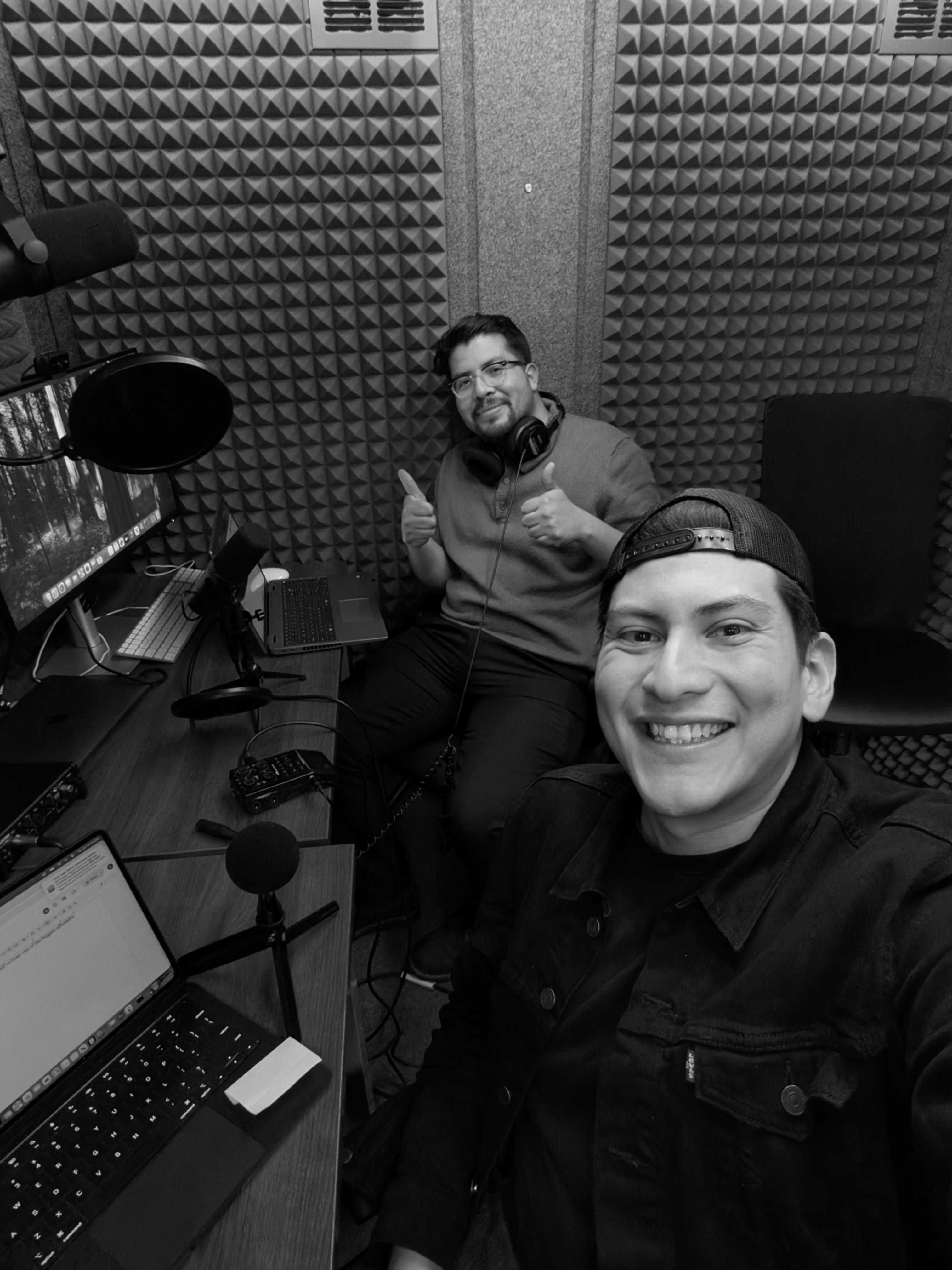 two people in recording studio smiling at the camera