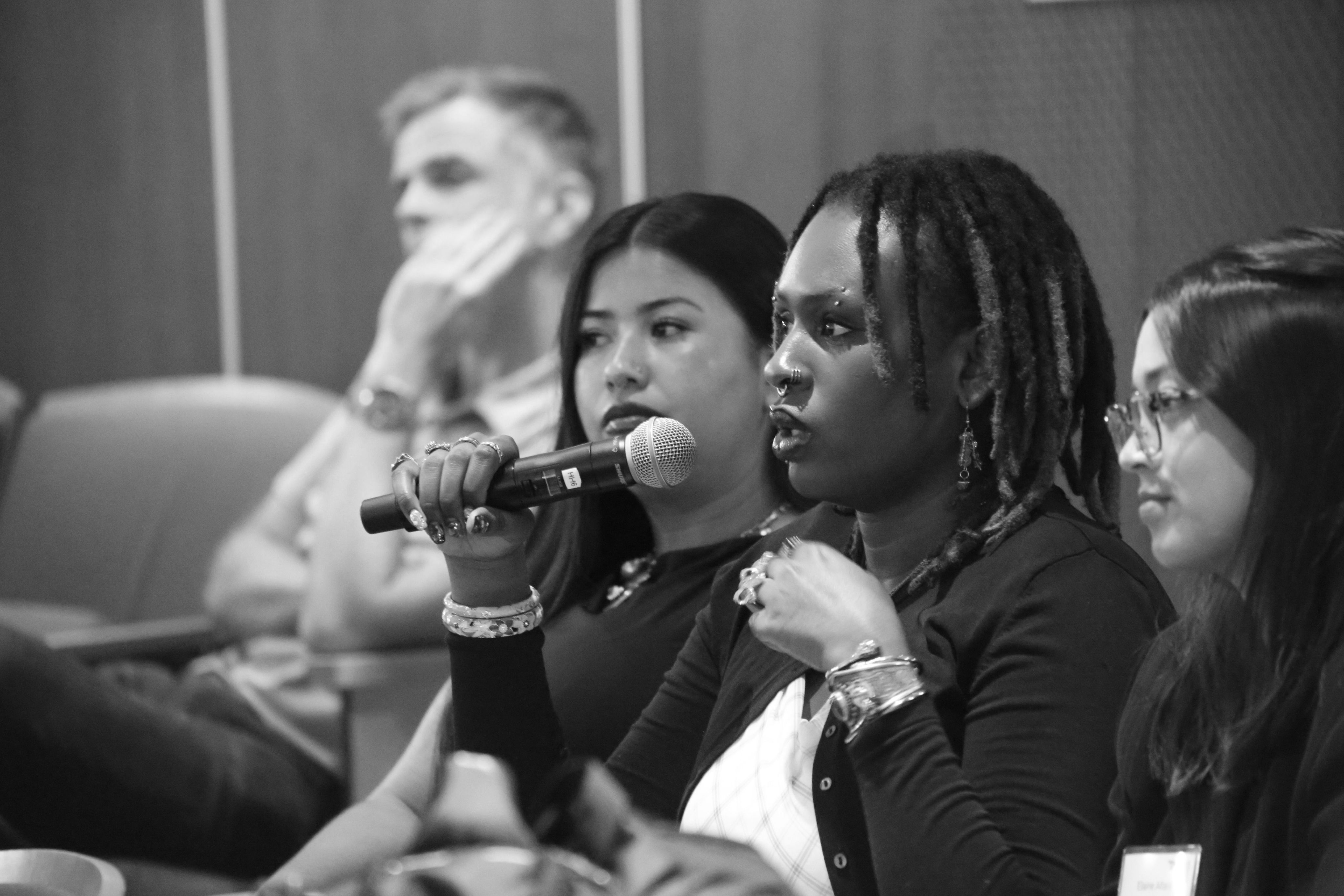 The face of a woman holding an a microphone. 