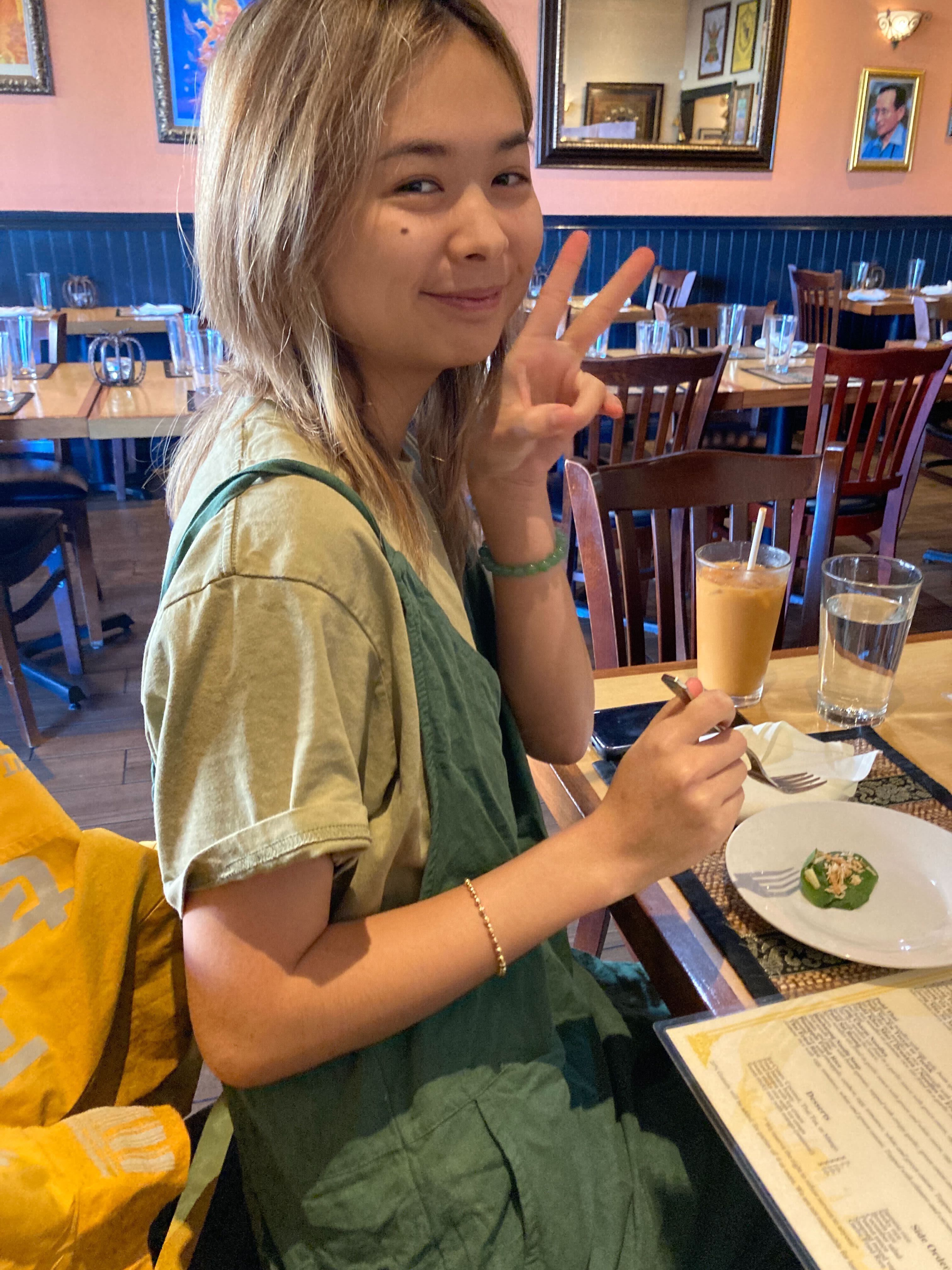 a fellow gives a peace sign to the camera and smiles. 