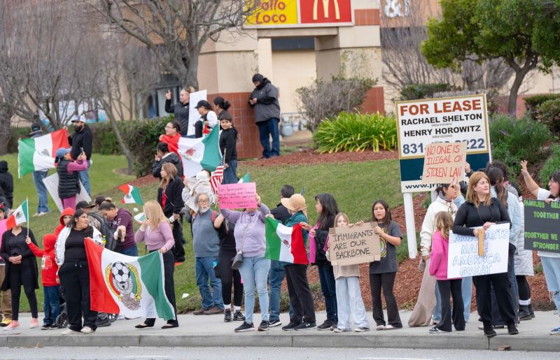 People protesting with pro-immigrant signs and Mexican flags