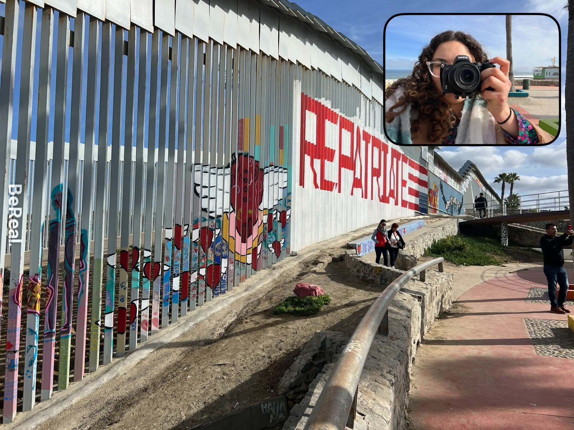 Woman photographs the border between the U.S. and Mexico. 