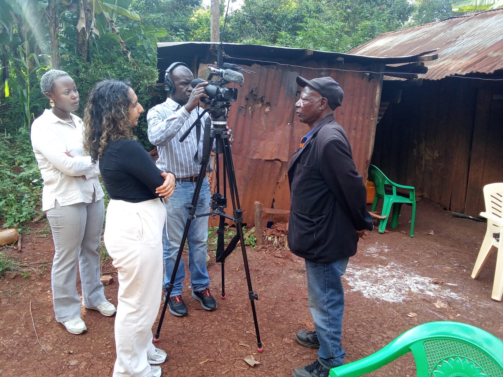 Inaara Gangji interviews a man in a black sports coat and jeans. Another man films and another woman looks on.