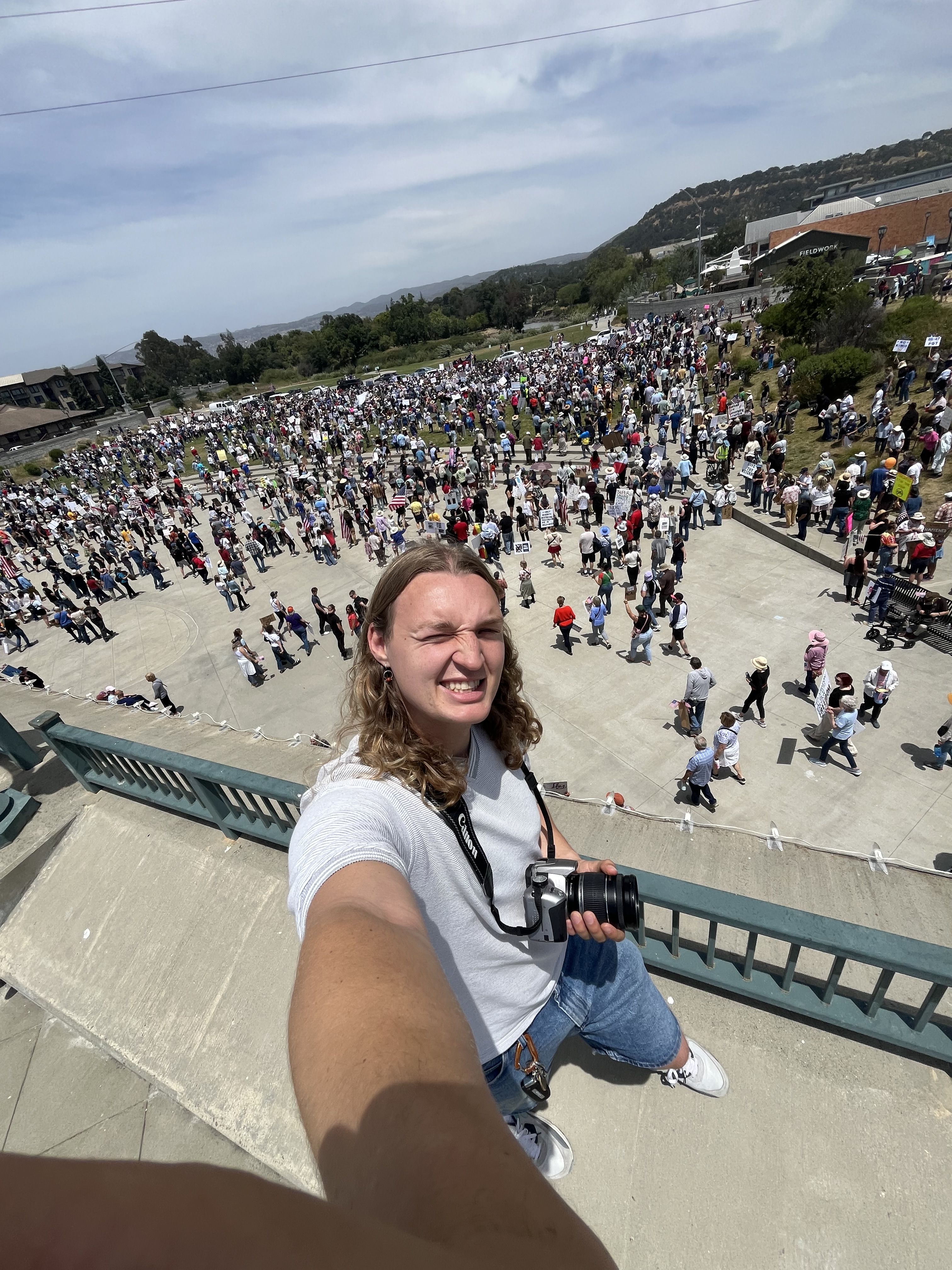 Xavey Bzdek takes a selfie in front of a crowd of people. 